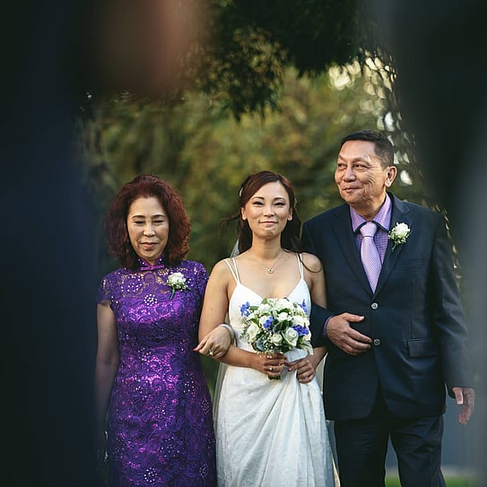 bride walking down the aisle with both parents