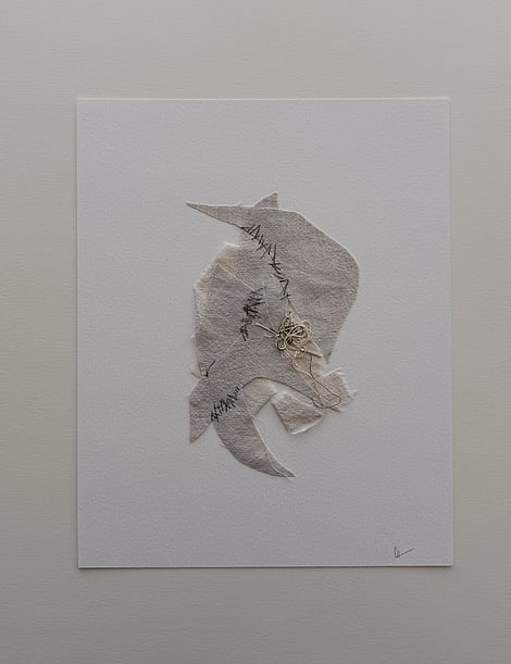 full image of a layered collage on ivory fabriano with an oatmeal-toned linen base twisted into a ribbon-like form and angular fawn-toned linen fragments layered above, showing hand-stitched segments in dark grey-green, soft frayed edges and a messy swirl of thread remnants resting on top in the centre, with handwritten signature in lower right corner