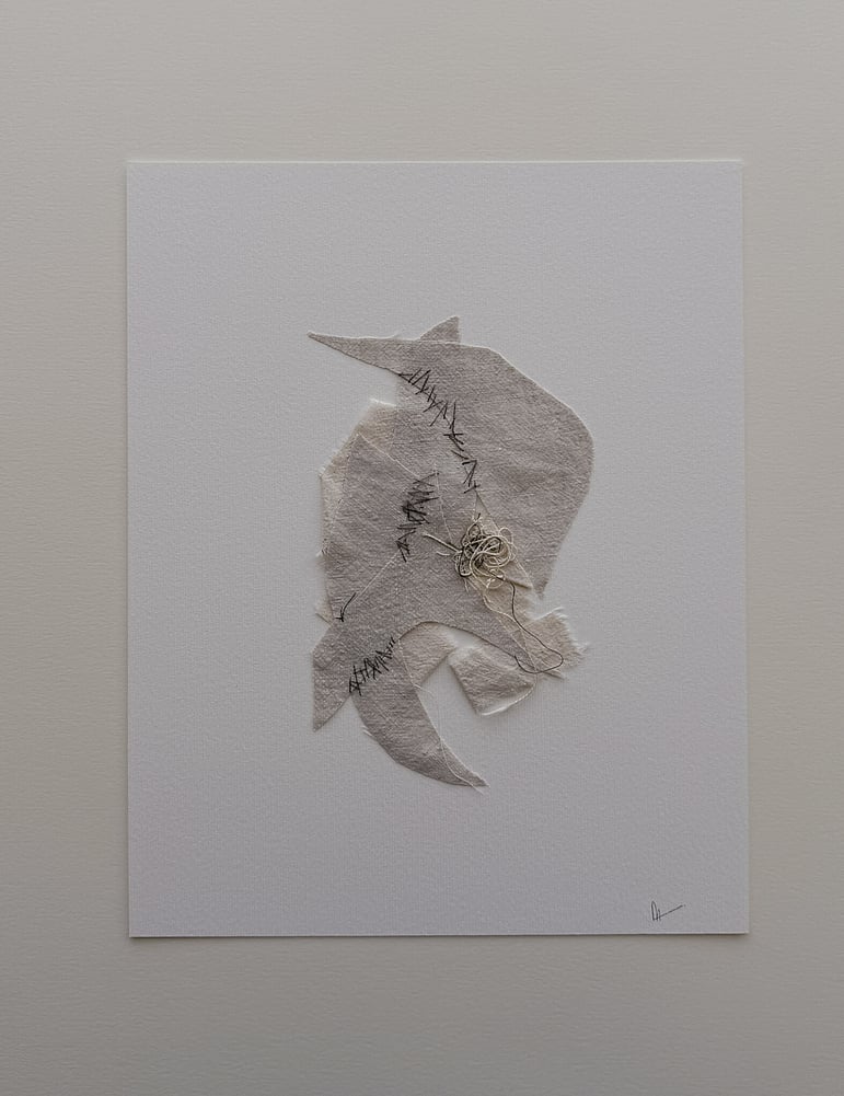 full image of a layered collage on soft white fabriano, showing repurposed oat and fawn-toned linen, with the oat-toned base twisted into a ribbon-like form and angular fawn-toned fragments layered on top, hand-stitched detail, visible weave texture, soft frayed edges and a messy swirl of thread remnants resting on one of the fragments, with hanging threads and handwritten signature in lower right corner 