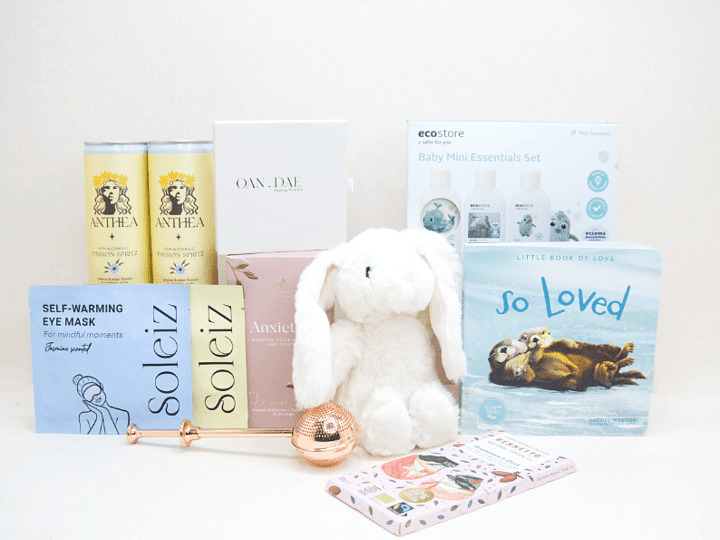 The New Chapter Gift Box featuring a bunny soft toy, baby memory book, OAN DAE Wish Kit, Soleiz eye masks, Anthea 0% Passionfruit Spritz, Anxiety Tea with tea infuser, Ecostore Mini Essentials Set, and a handwritten gift card, beautifully presented in a premium KYND gift box.