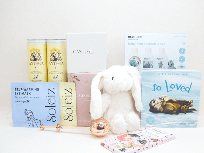 The New Chapter Gift Box featuring a bunny soft toy, baby memory book, OAN DAE Wish Kit, Soleiz eye masks, Anthea 0% Passionfruit Spritz, Anxiety Tea with tea infuser, Ecostore Mini Essentials Set, and a handwritten gift card, beautifully presented in a premium KYND gift box.