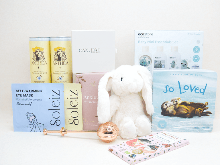 The New Chapter Gift Box featuring a bunny soft toy, baby memory book, OAN DAE Wish Kit, Soleiz eye masks, Anthea 0% Passionfruit Spritz, Anxiety Tea with tea infuser, Ecostore Mini Essentials Set, and a handwritten gift card, beautifully presented in a premium KYND gift box.
