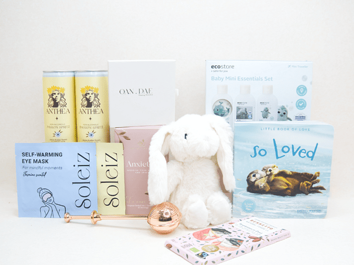 The New Chapter Gift Box featuring a bunny soft toy, baby memory book, OAN DAE Wish Kit, Soleiz eye masks, Anthea 0% Passionfruit Spritz, Anxiety Tea with tea infuser, Ecostore Mini Essentials Set, and a handwritten gift card, beautifully presented in a premium KYND gift box.
