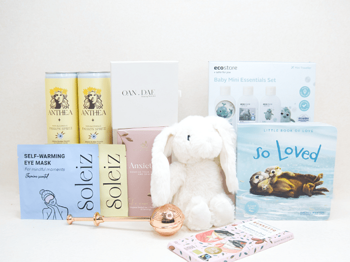 The New Chapter Gift Box featuring a bunny soft toy, baby memory book, OAN DAE Wish Kit, Soleiz eye masks, Anthea 0% Passionfruit Spritz, Anxiety Tea with tea infuser, Ecostore Mini Essentials Set, and a handwritten gift card, beautifully presented in a premium KYND gift box.