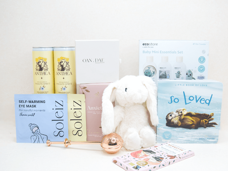 The New Chapter Gift Box featuring a bunny soft toy, baby memory book, OAN DAE Wish Kit, Soleiz eye masks, Anthea 0% Passionfruit Spritz, Anxiety Tea with tea infuser, Ecostore Mini Essentials Set, and a handwritten gift card, beautifully presented in a premium KYND gift box.