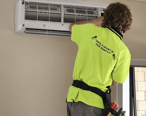 Heat pump technician installing a wall-mounted heat pump in a Hamilton home