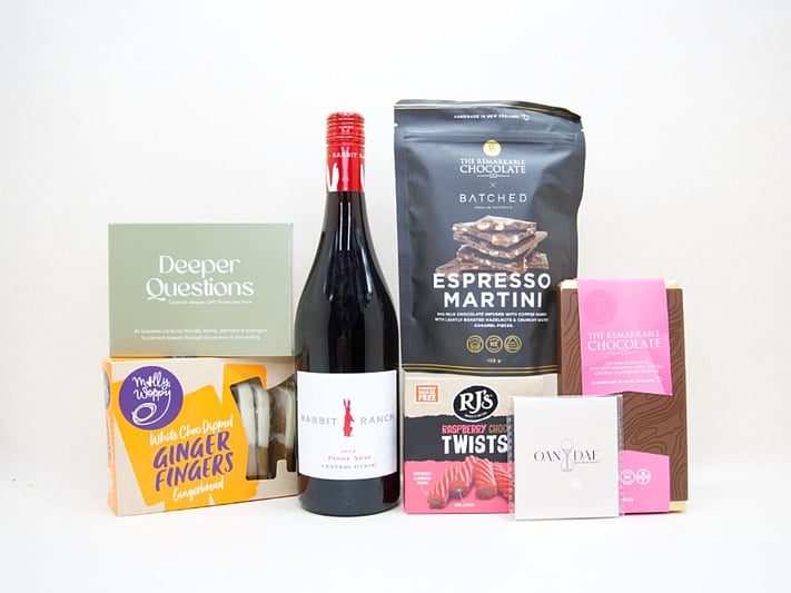 Let's Catch Up Gift Box featuring Rabbit Ranch Pinot Noir, Deeper Questions card game, OAN DAE mini wish kit, Remarkable Espresso Martini chocolate bark, Molly Woppy chocolate dipped shortbread, and RJ's Raspberry Chocolate Twists, thoughtfully packaged for meaningful conversations and shared moments.