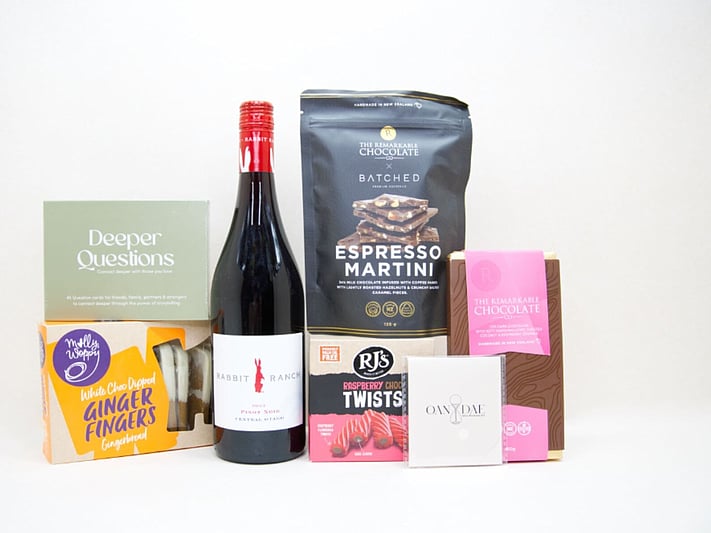 Let's Catch Up Gift Box featuring Rabbit Ranch Pinot Noir, Deeper Questions card game, OAN DAE mini wish kit, Remarkable Espresso Martini chocolate bark, Molly Woppy chocolate dipped shortbread, and RJ's Raspberry Chocolate Twists, thoughtfully packaged for meaningful conversations and shared moments.
