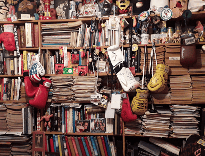 Photo of shelves full of files, books, memorabilia, boxing gloves etc.