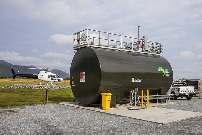 Jet A-1 bulk fuel storage tank branded RD Petroleum Aviation at a West Coast airstrip, with a helicopter on the pad alongside.