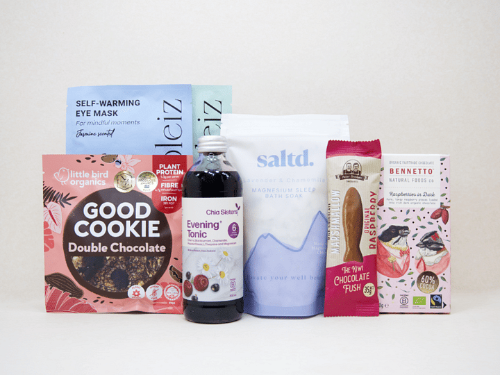 A Little Unwind Gift Box featuring Chia Sisters Evening Tonic, Saltd Magnesium Soak, Soleiz eye masks, Little Bird Organics Good Cookie, Bennetto raspberry chocolate, and Potter Brothers raspberry chocolate fish, thoughtfully curated for relaxation, rest, and self-care.