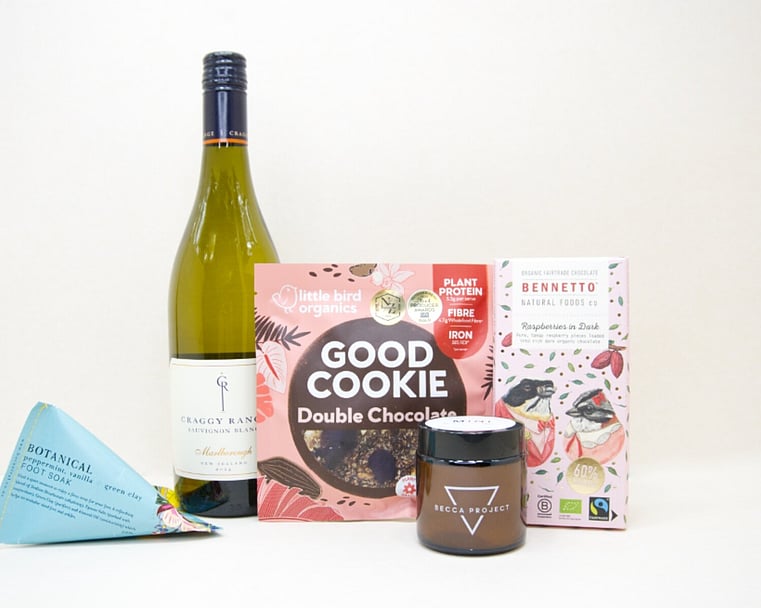 A Moment For You Gift Box featuring Craggy Range Sauvignon Blanc, a Becca Project candle, Botanicals foot soak, Little Bird Organics Good Cookie, and Bennetto raspberry chocolate, thoughtfully curated for relaxation, self-care, and everyday indulgence.