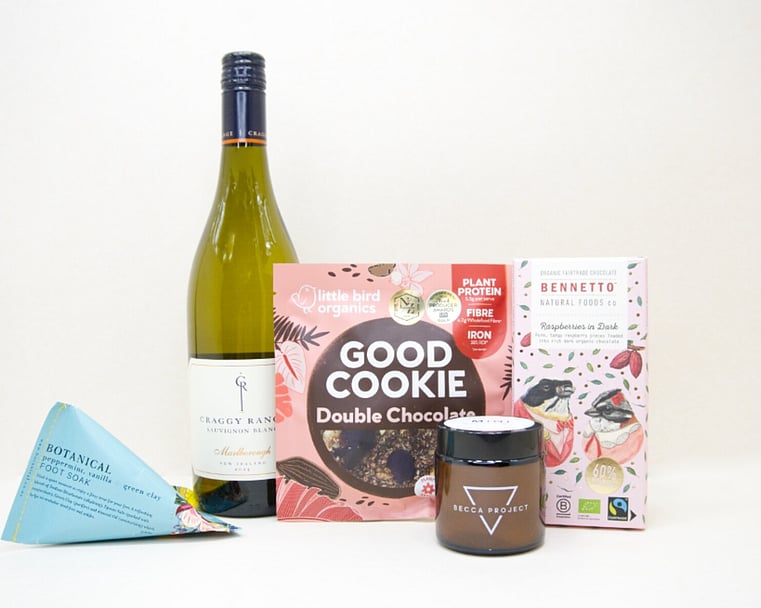 A Moment For You Gift Box featuring Craggy Range Sauvignon Blanc, a Becca Project candle, Botanicals foot soak, Little Bird Organics Good Cookie, and Bennetto raspberry chocolate, thoughtfully curated for relaxation, self-care, and everyday indulgence.