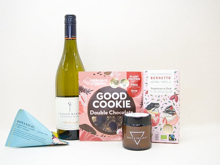 A Moment For You Gift Box featuring Craggy Range Sauvignon Blanc, a Becca Project candle, Botanicals foot soak, Little Bird Organics Good Cookie, and Bennetto raspberry chocolate, thoughtfully curated for relaxation, self-care, and everyday indulgence.