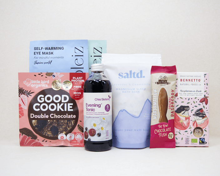 A Little Unwind Gift Box featuring Chia Sisters Evening Tonic, Saltd Magnesium Soak, Soleiz eye masks, Little Bird Organics Good Cookie, Bennetto raspberry chocolate, and Potter Brothers raspberry chocolate fish, thoughtfully curated for relaxation, rest, and self-care.