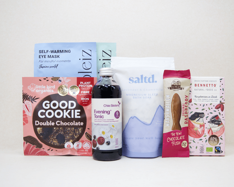 A Little Unwind Gift Box featuring Chia Sisters Evening Tonic, Saltd Magnesium Soak, Soleiz eye masks, Little Bird Organics Good Cookie, Bennetto raspberry chocolate, and Potter Brothers raspberry chocolate fish, thoughtfully curated for relaxation, rest, and self-care.