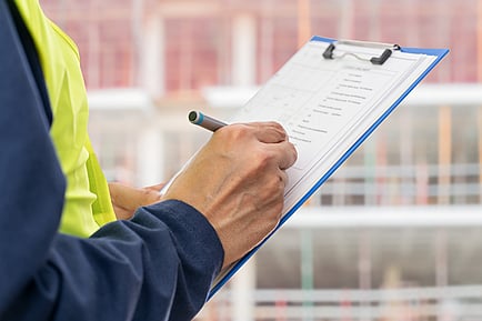 Tradie checking health and safety records at a New Zealand worksite.