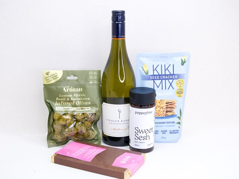 A Moment For You Gift Box featuring Craggy Range Sauvignon Blanc, a Becca Project candle, Botanicals foot soak, Little Bird Organics Good Cookie, and Bennetto raspberry chocolate, thoughtfully curated for relaxation, self-care, and everyday indulgence.