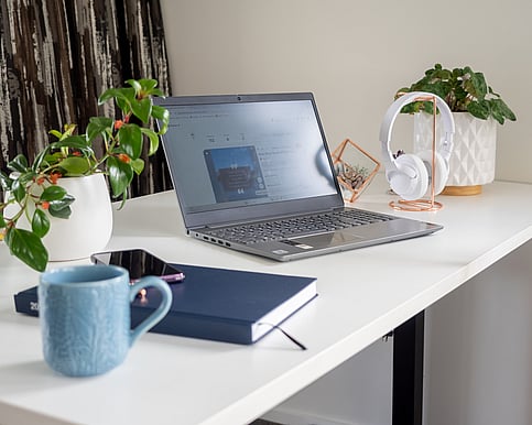 Image of a laptop on a desk with the text "content keeps working"