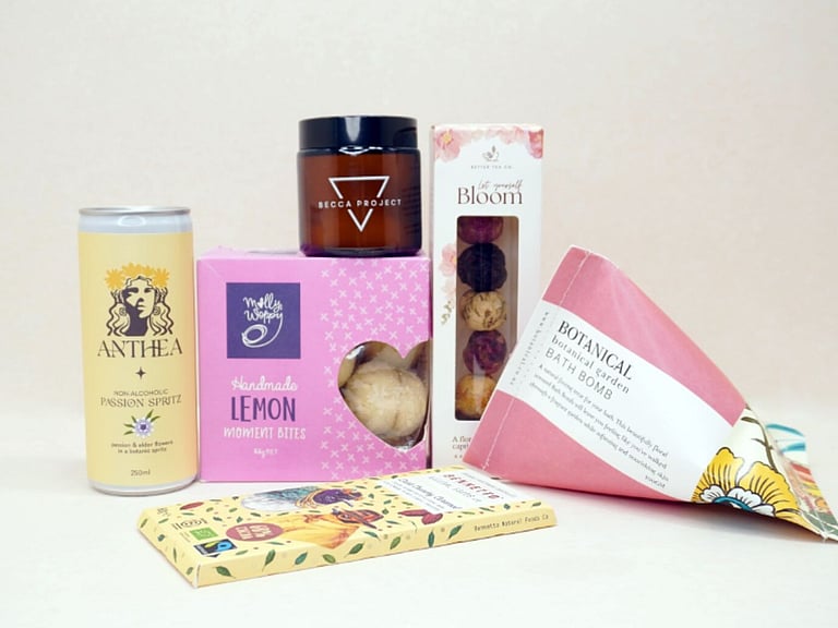 Just Lovely Gift Box featuring Better Tea Co blooming tea balls, Anthea cocktail, Becca Project Stella candle, Botanicals bath bomb, Molly Woppy Lemon Moments, and Bennetto salted caramel chocolate, thoughtfully curated to brighten someone's day and encourage relaxation.