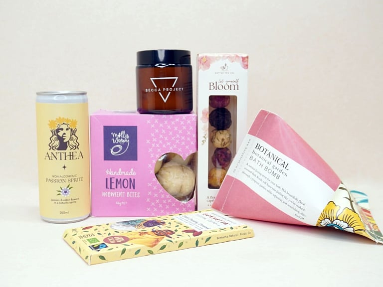 Just Lovely Gift Box featuring Better Tea Co blooming tea balls, Anthea cocktail, Becca Project Stella candle, Botanicals bath bomb, Molly Woppy Lemon Moments, and Bennetto salted caramel chocolate, thoughtfully curated to brighten someone's day and encourage relaxation.