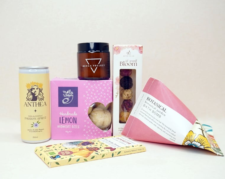Just Lovely Gift Box featuring Better Tea Co blooming tea balls, Anthea cocktail, Becca Project Stella candle, Botanicals bath bomb, Molly Woppy Lemon Moments, and Bennetto salted caramel chocolate, thoughtfully curated to brighten someone's day and encourage relaxation.