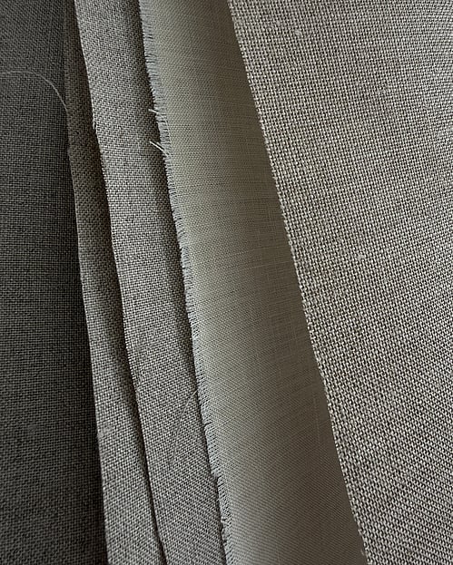 natural zweigart and danish linens, arranged vertically side by side, ranging from natural flax tones to pale cream linen, with contrasting weave densities, surface textures and softly frayed edges
