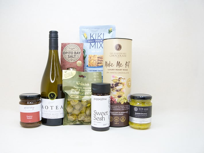 Food & Wine Hamper featuring Aotea Sauvignon Blanc, artisan olives with lemon myrtle and kawakawa, Kiki Seed Crackers, The Kitchen Window Piccalilli, Preservation Festive Chutney, Pepper & Me Hot Honey, Opito Bay Chilli Salt, and a Remarkables Rocky Road Kit, thoughtfully curated for entertaining, grazing, and gourmet gifting.
