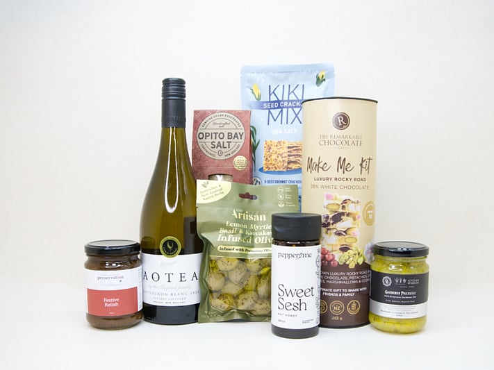Food & Wine Hamper featuring Aotea Sauvignon Blanc, artisan olives with lemon myrtle and kawakawa, Kiki Seed Crackers, The Kitchen Window Piccalilli, Preservation Festive Chutney, Pepper & Me Hot Honey, Opito Bay Chilli Salt, and a Remarkables Rocky Road Kit, thoughtfully curated for entertaining, grazing, and gourmet gifting.