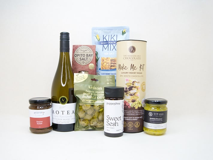 Food & Wine Hamper featuring Aotea Sauvignon Blanc, artisan olives with lemon myrtle and kawakawa, Kiki Seed Crackers, The Kitchen Window Piccalilli, Preservation Festive Chutney, Pepper & Me Hot Honey, Opito Bay Chilli Salt, and a Remarkables Rocky Road Kit, thoughtfully curated for entertaining, grazing, and gourmet gifting.