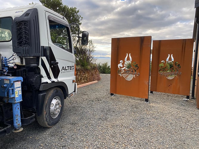 Corten steel screening panels with a laser-cut family crest at a Te Rerenga home