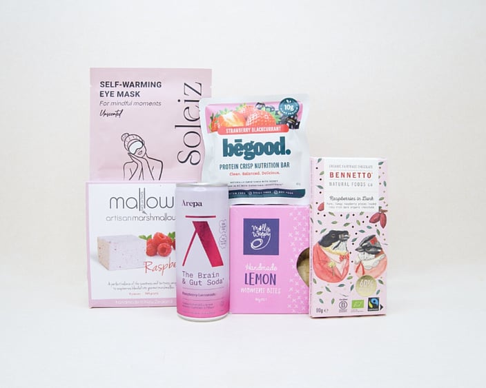 The Feel Good Gift Box featuring an Ārepa Raspberry Lemonade Brain Drink, Soleiz Eye Mask, Bennetto chocolate, Mallow marshmallows, Be Good snack, and Molly Woppy Lemon Moments, thoughtfully curated for gifting in New Zealand.