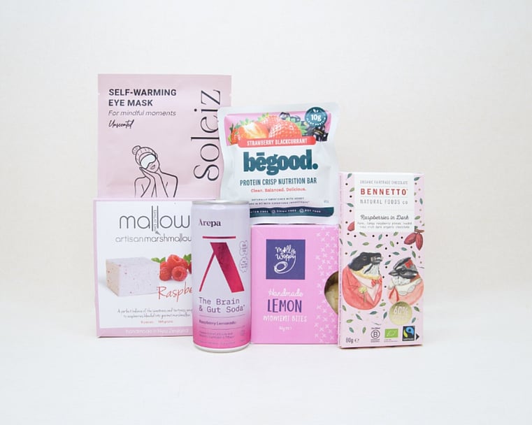 The Feel Good Gift Box featuring an Ārepa Raspberry Lemonade Brain Drink, Soleiz Eye Mask, Bennetto chocolate, Mallow marshmallows, Be Good snack, and Molly Woppy Lemon Moments, thoughtfully curated for gifting in New Zealand.