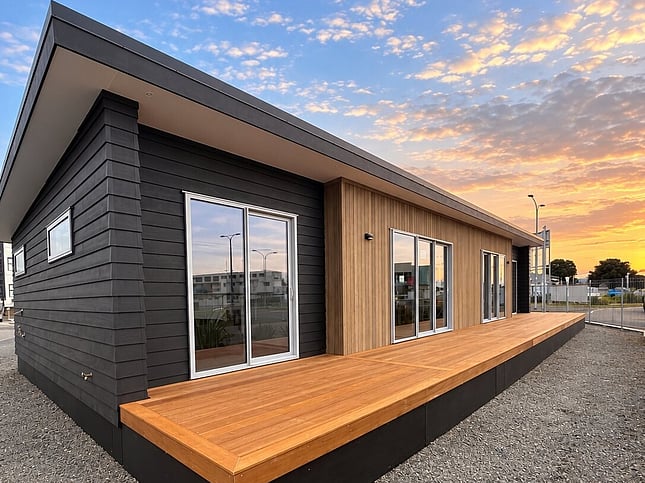Dark weatherboards and vertical cladding with a timber deck