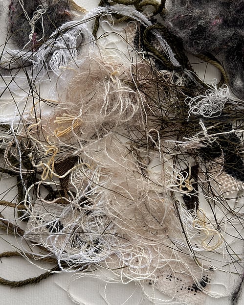 detail image of repurposed yarn, threads and fabric remnants in neutral tones, showing a messy cluster of tangled loops, soft frayed fibres and varied weave textures