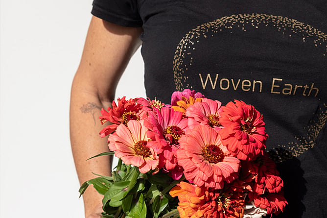 Woven Earth team member with flowers for a home.