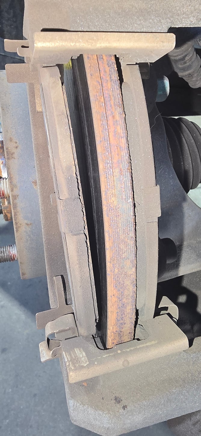 Rear brake disc and pad assembly on a Mazda CX-5 during inspection.