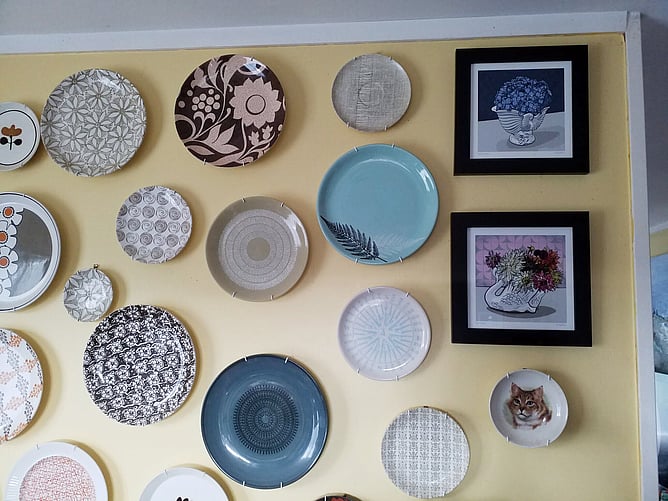 Crown Lynn plate collection on a yellow wall with framed Crowned Hydrangea and Crowned Dahlia art prints by Anna Mollekin