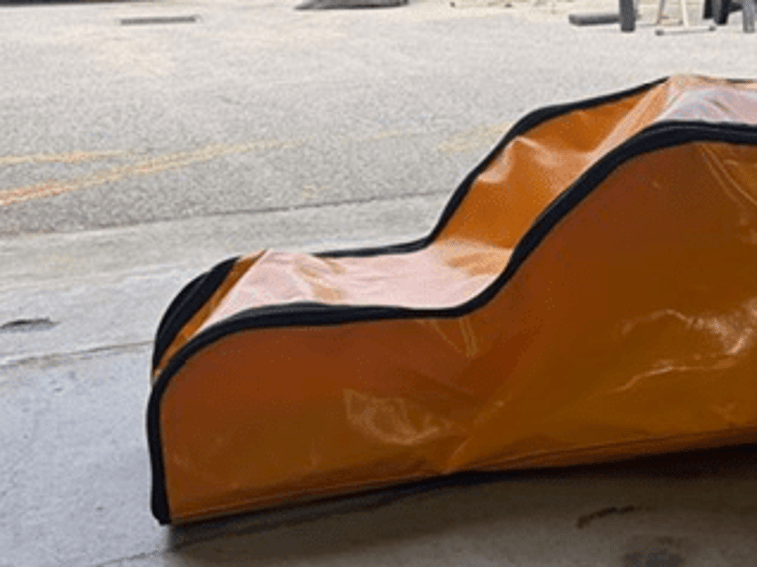 Close side view of a shaped orange PVC rope ladder bag