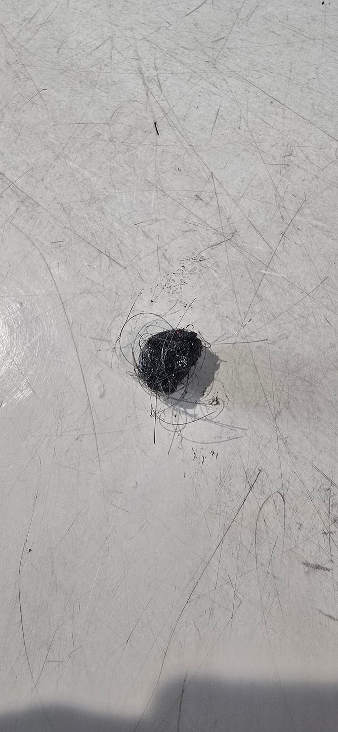 Hair-covered stone removed from beneath the MINI seat release mechanism.