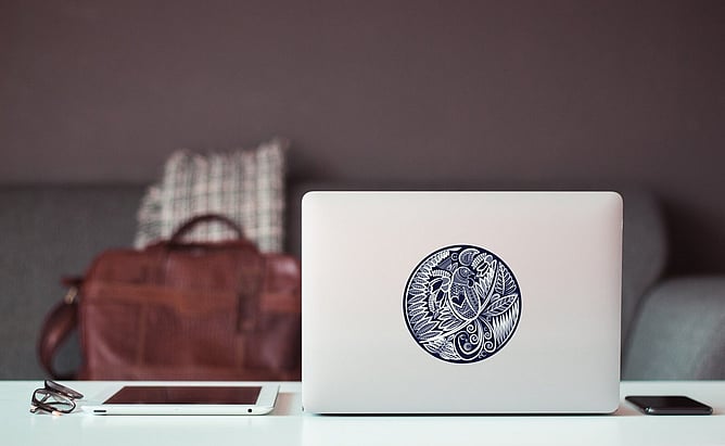 Homegrown Lace tūī decal by Anna Mollekin on a laptop, a small native bird gift from New Zealand
