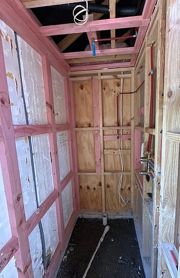 Shower before the renovation, framed up with new pipework run