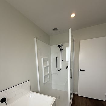 Completed bathroom with a freestanding bath, shower and black tapware