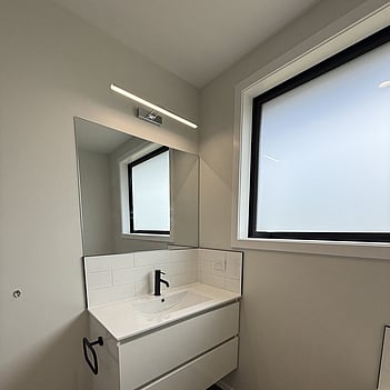 Wall-hung vanity with a basin and black tapware