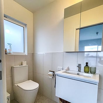 Completed bathroom install with a new toilet and vanity basin