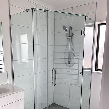 Frameless glass shower enclosure in a completed bathroom