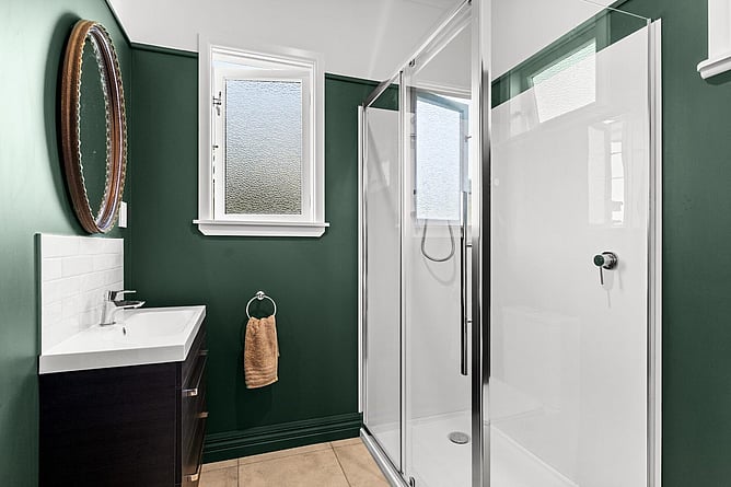 Renovated ensuite with a green feature wall, new shower and vanity