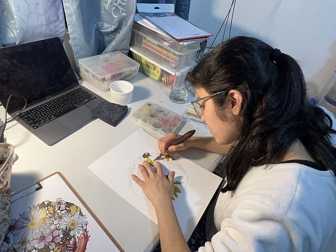 Emy Oikawa making clay wall art at her desk in Wellington