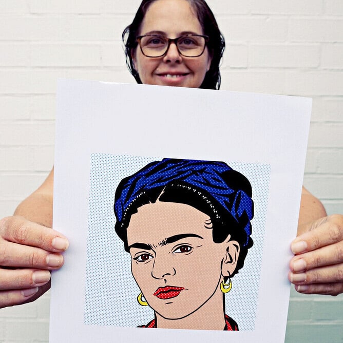 Anna Mollekin holding her pop art Frida Kahlo artwork with Ben Day dot background