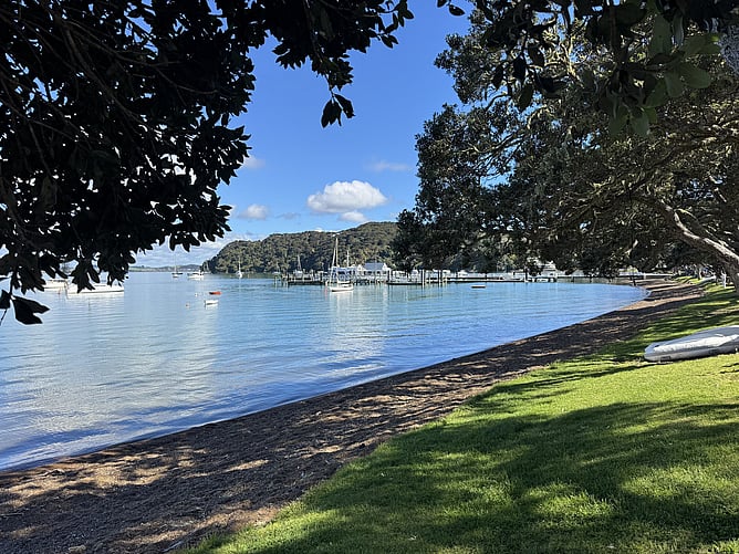 Scenic view of the historic Russell waterfront on a calm, clear day with blue skies and still blue water in the Bay of Islands